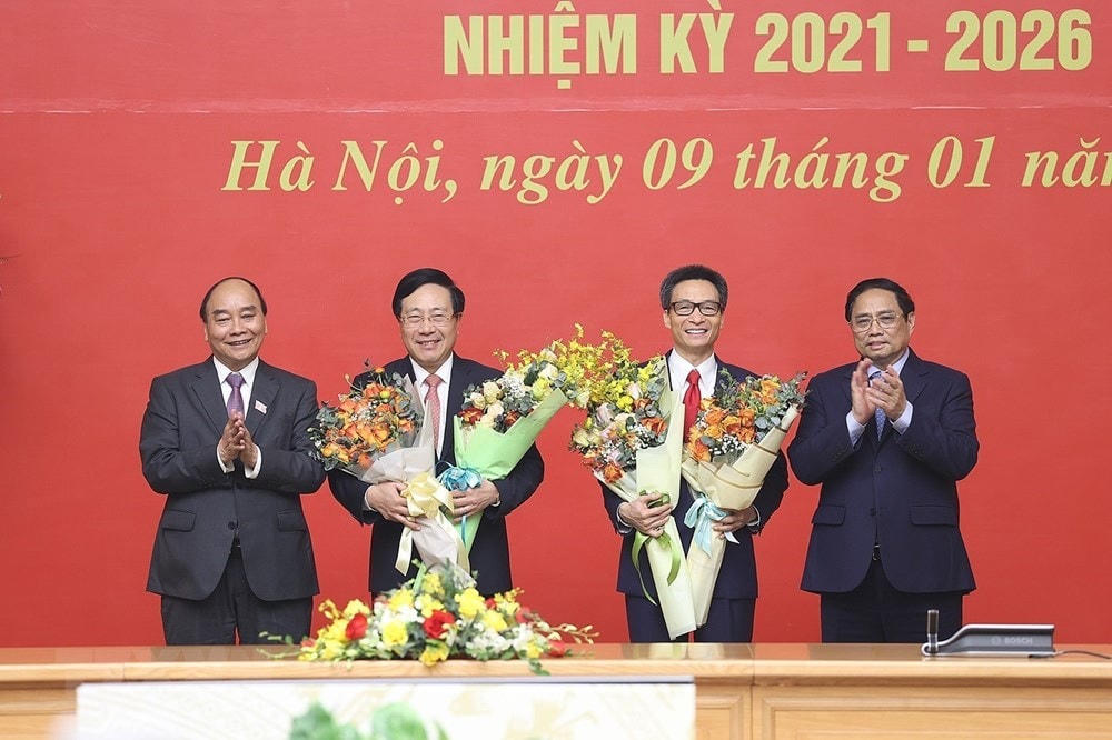 Chủ tịch nước Nguyễn Xuân Phúc và Thủ tướng Phạm Minh Chính tặng hoa chia tay ông Phạm Bình Minh và ông Vũ Đức Đam. (Ảnh: Dương Giang/TTXVN).