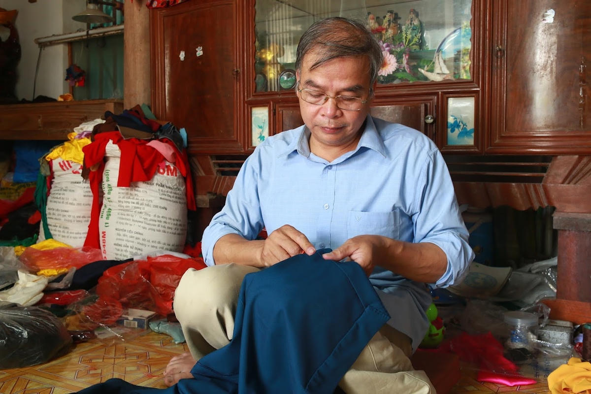 Nghệ nhân Đỗ Minh Tám khâu chiếc áo ngũ thân theo bí quyết khâu kim tay dọc.  