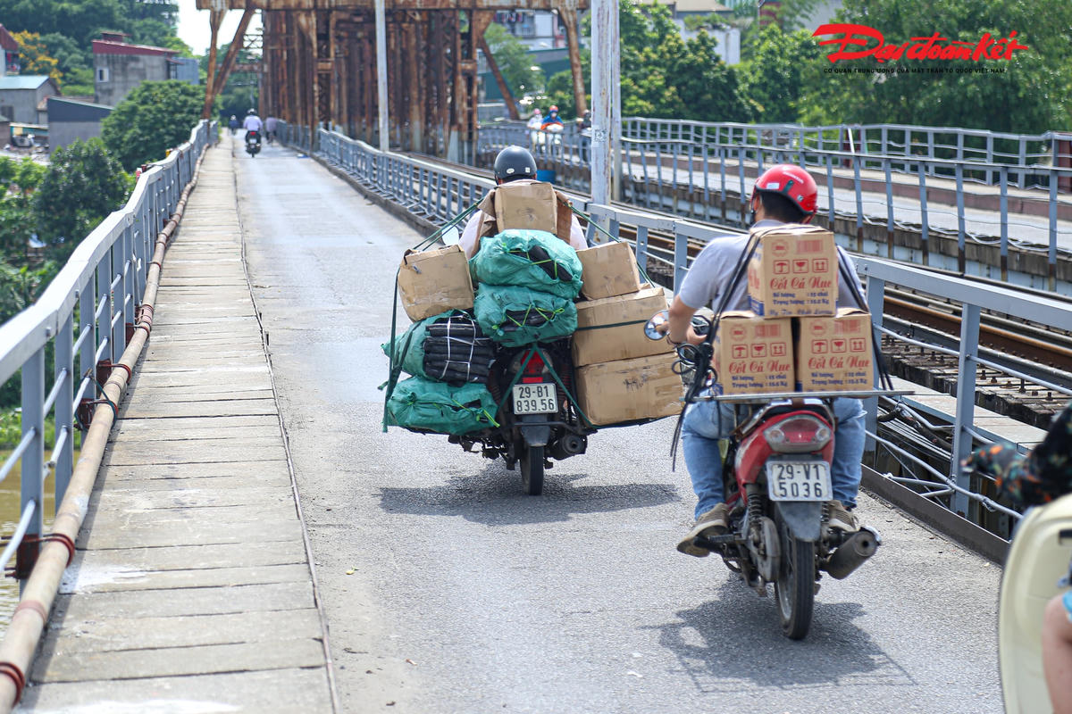 Không chỉ có người đi bộ trên cầu bộ hành, mà hàng loạt phương tiện xe máy thồ bất chấp nguy hiểm di chuyển lên cầu.