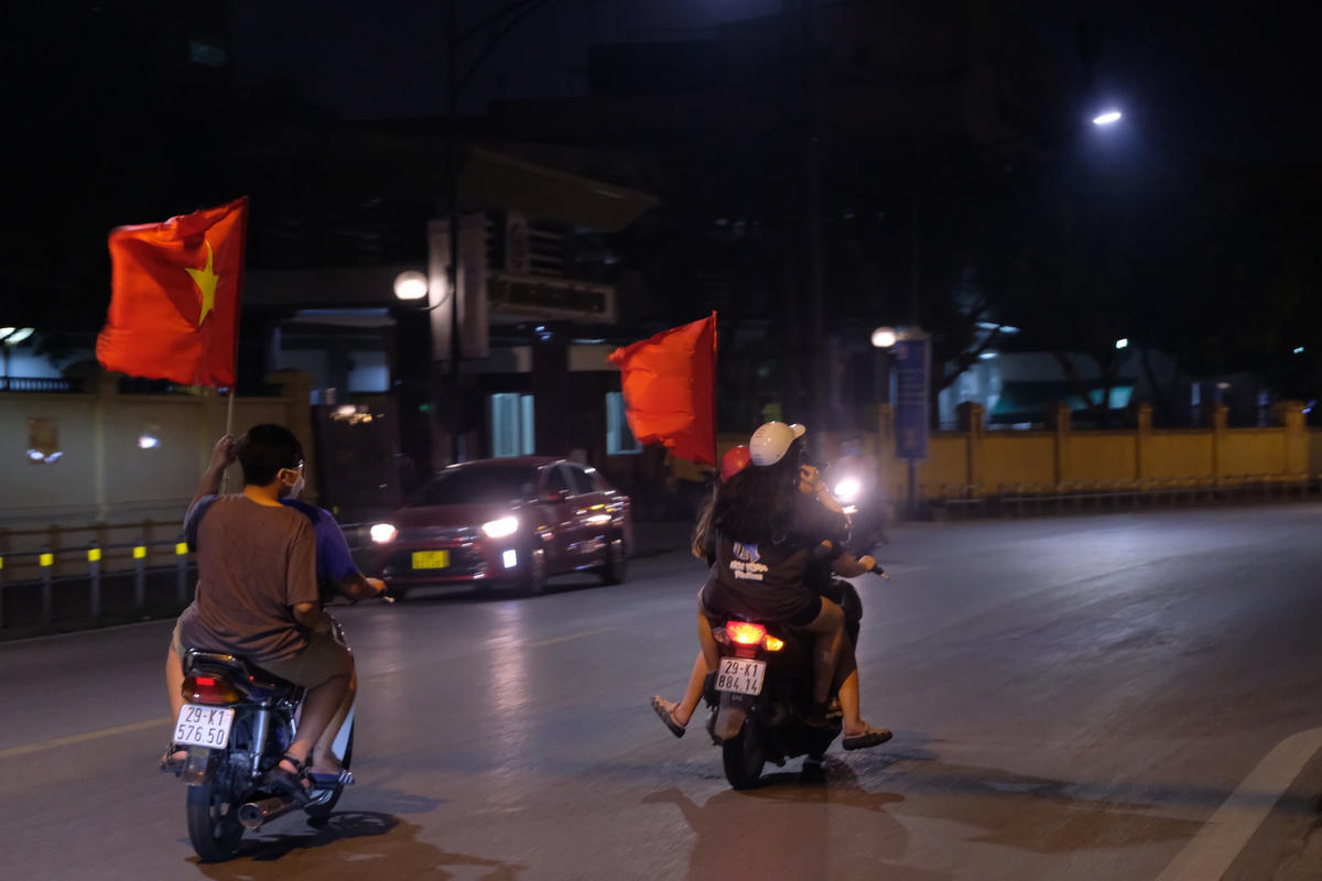 Các thanh niên mang theo cờ, reo hò mừng chiến thắng.