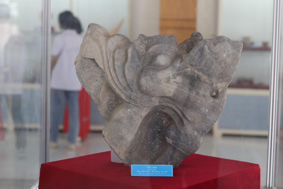 Đầu rồng đá thời Trần - Hồ dùng trang trí kiến trúc bậc thềm cung điện. Hiện vật có màu xanh xám, trang trí một mặt khá tinh xảo.  