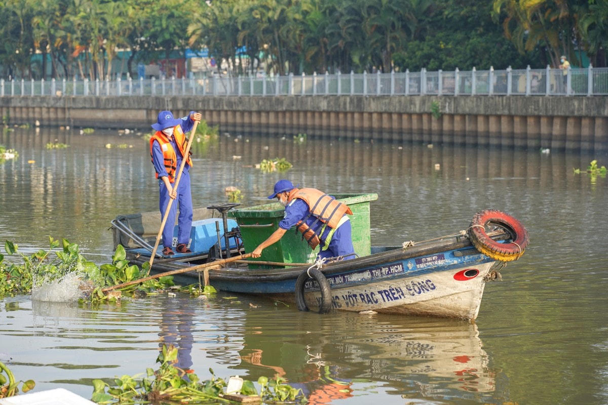 Công nhân vớt rác thải trên kênh Tân Hóa-Lò Gốm ở TP Hồ Chí Minh.