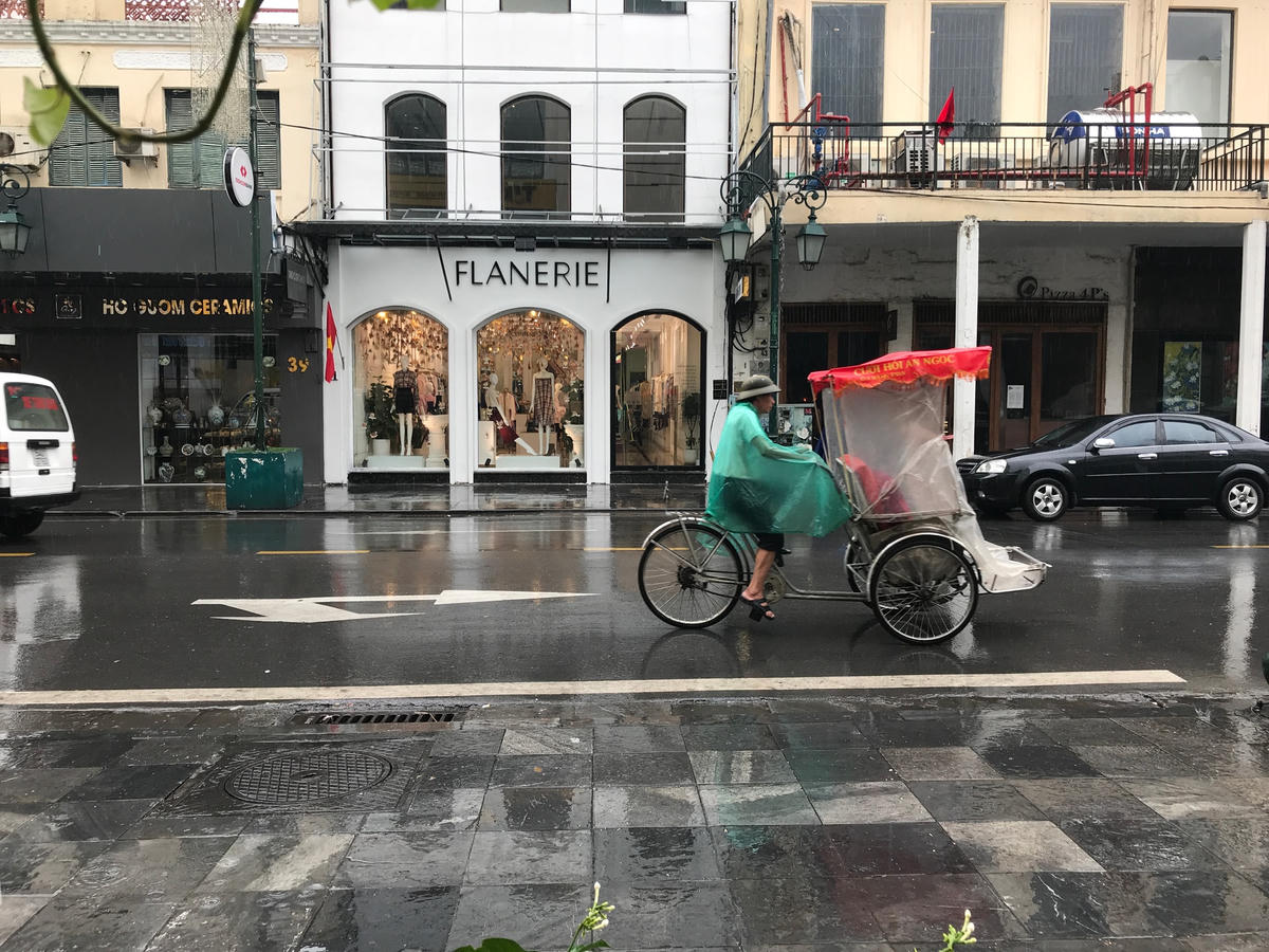Hình ảnh xích lô và ô tô trên phố Tràng Tiền (Hà Nội).  