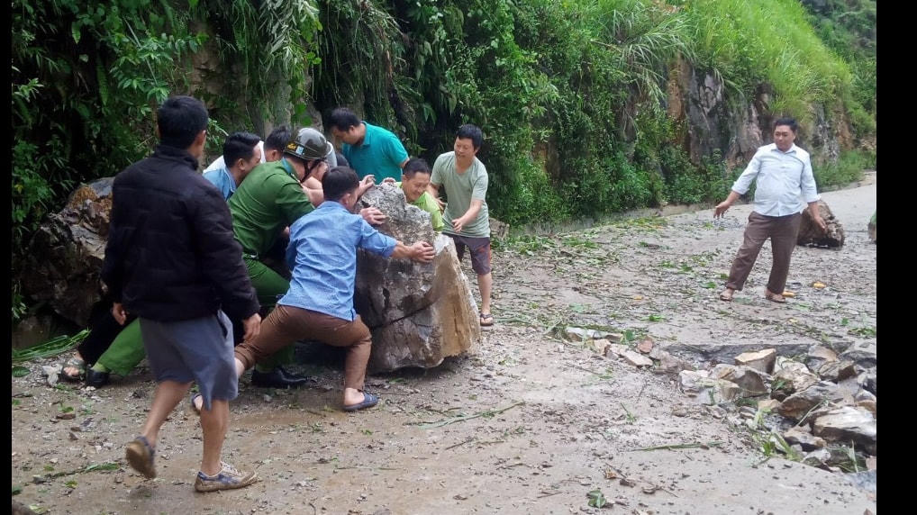 Người dân hỗ trợ vận chuyển đá bị sạt lở.