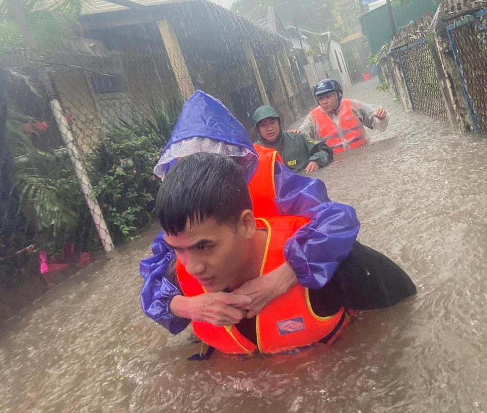 Lực lượng chức năng vượt dòng nước lũ đưa người dân đến nơi an toàn. Ảnh: CTV.