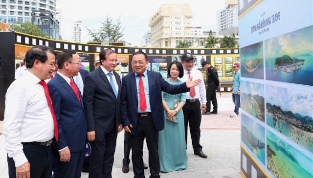 Các đại biểu đang đi thăm nơi trưng bày ảnh.