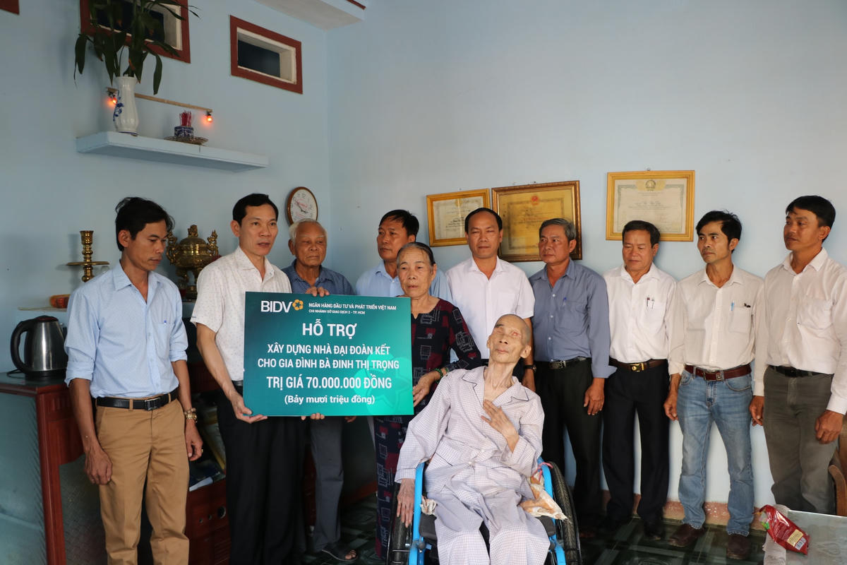 Ông Võ Thanh An trao bảng tượng trưng và tặng quà cho gia đình bà Đinh Thị Trọng.