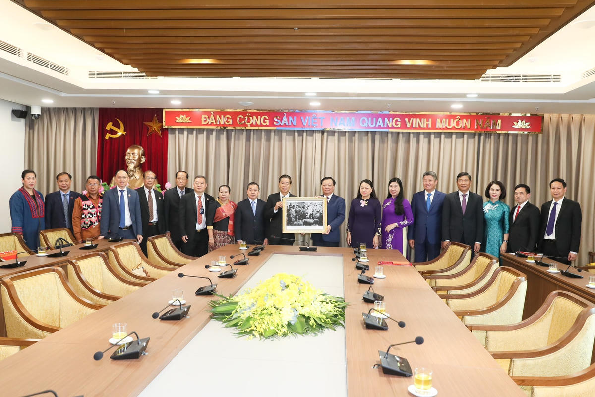 Bí thư Thành ủy Hà Nội Đinh Tiến Dũng, Chủ tịch Ủy ban Trung ương Mặt trận Lào xây dựng đất nước Sinlavong Khoutphaythoune cùng các đại biểu chụp ảnh chung. Ảnh: Quang Vinh.
