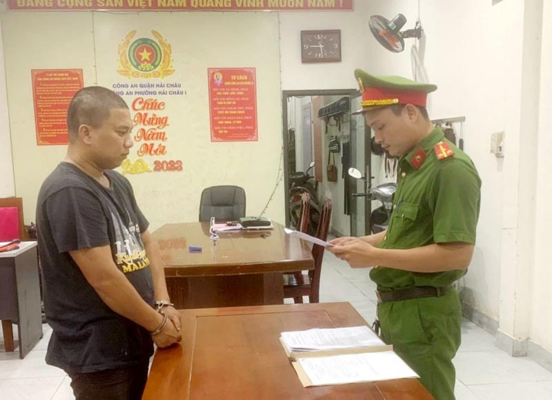 Nguyễn Quốc Nhựt nghe công an đọc lệnh khởi tố. Ảnh: Công an Đà Nẵng.