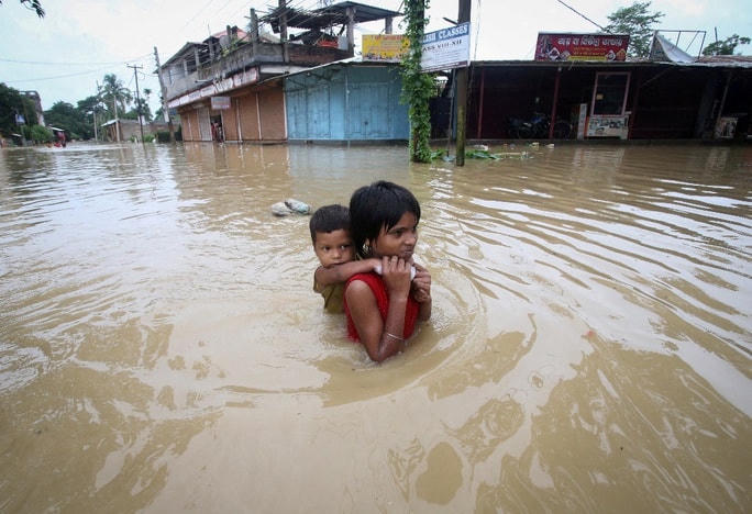 Cõng em trên con đường ngập sâu do mưa lớn ở ngoại ô Agartala - Ấn Độ. Ảnh: Reuters.