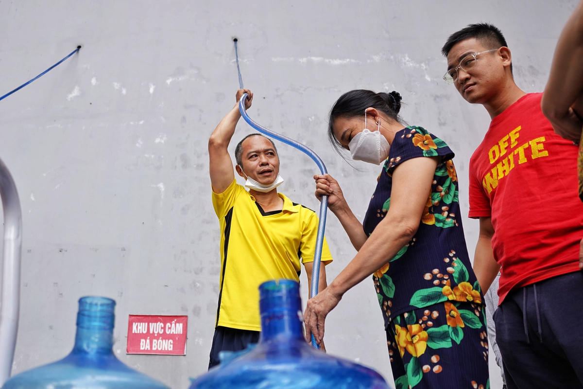 Nước chảy chậm người dân phải dùng tay nâng vòi.