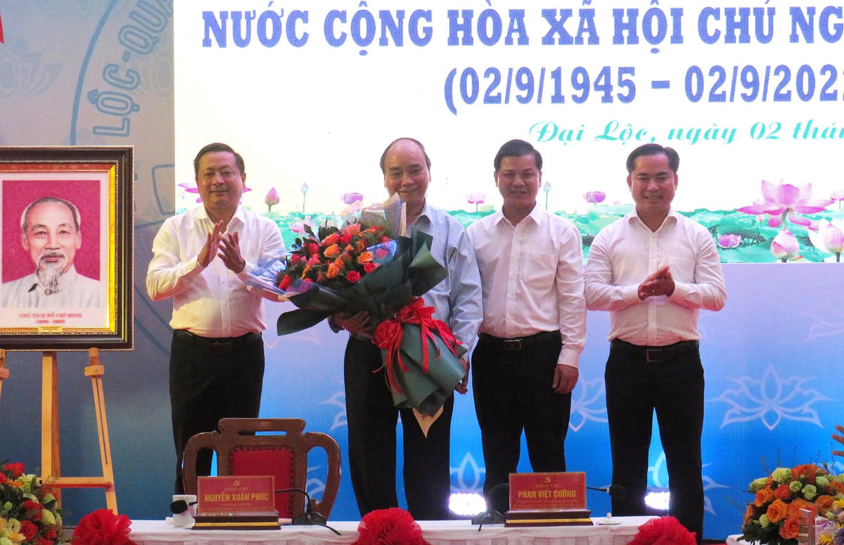 Lãnh đạo huyện Đại Lộc tặng hoa Chủ tịch nước Nguyễn Xuân Phúc tại buổi gặp mặt.