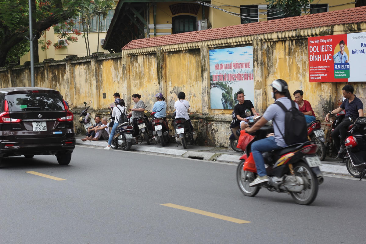 Hình ảnh phụ huynh đứng đợi kéo dài trên vỉa hè. Ảnh: Ngọc Ánh.