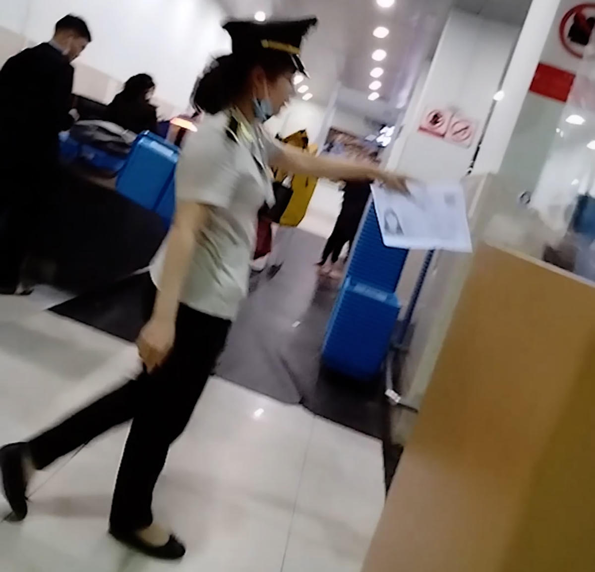 Một người mặc trang phục an ninh Cảng hàng không quốc tế Phú Bài dẫn hành khách không giấy tờ qua cửa an ninh lên tàu bay sau khi người khách này chuyển gần 1,5 triệu đồng cho đại lý. Ảnh: cắt từ clip.