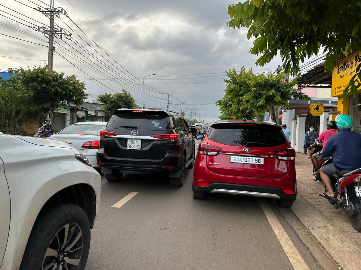 Một chiếc xe hơi đậu dưới làn đường nhỏ hẹp, khiến xe máy phải leo lề để di chuyển, các xe ô tô khác cũng di chuyển tương dối khó khăn ở đường Hồ Thị Hương. Ảnh: Mạnh Thìn.