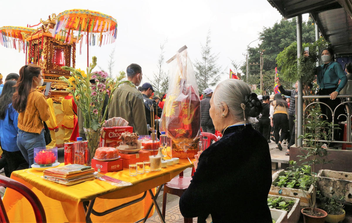 Người dân chuẩn bị mâm lễ để cúng Đức Ông và các nhân thần khi đoàn rước lễ đi qua.