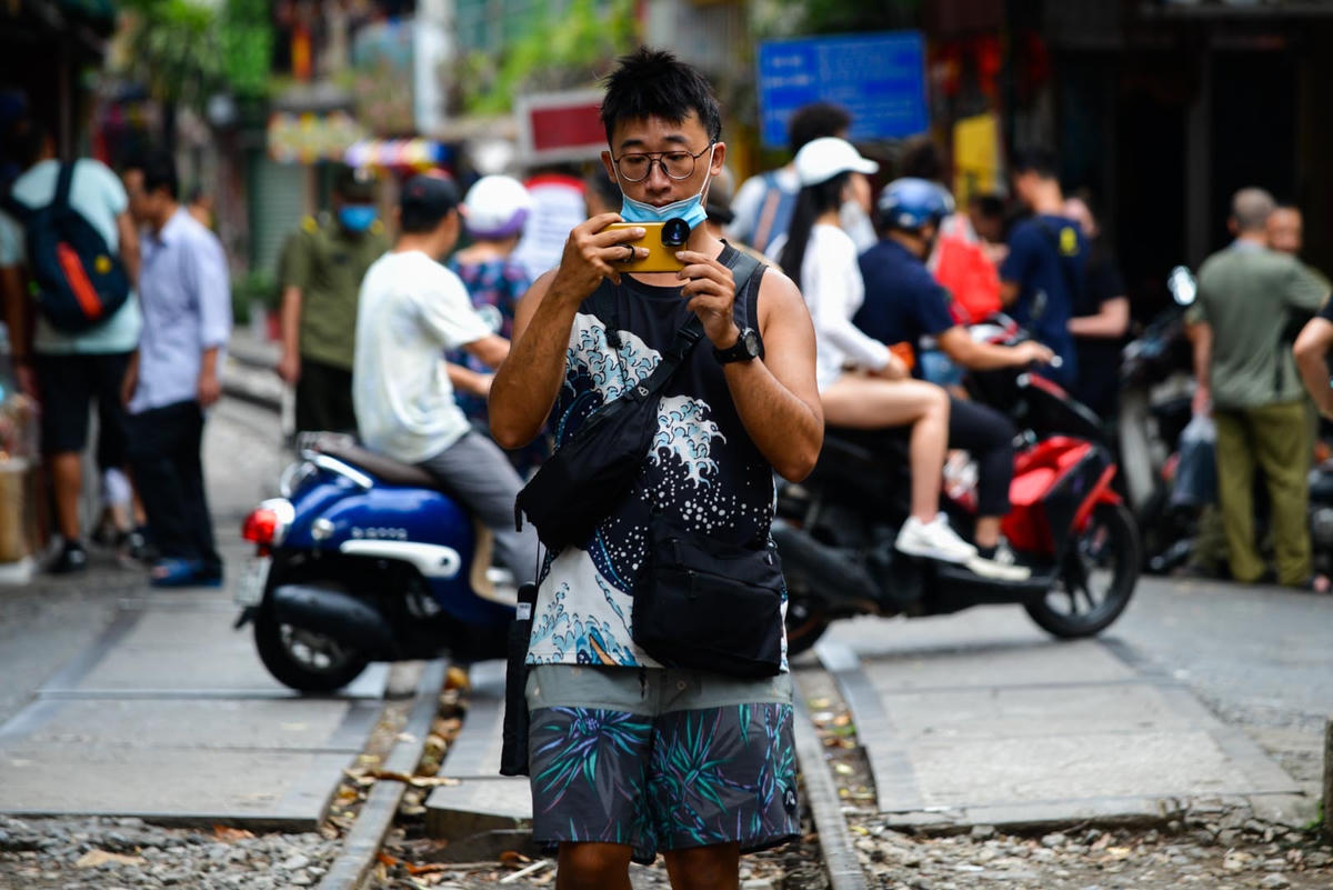 Du khách đến đây check in, quay phim, chụp ảnh không hề ít hơn con phố đường tàu đã bị chặn là bao. "Tôi nghe bạn bè nói rất nhiều về con phố đường tàu tại Hà Nội, tuy không thực sự được đi vào trong con phố tôi mong chờ nhưng như thế này cũng đủ thỏa mãn tôi rồi", một du khách Trung Quốc chia sẻ.