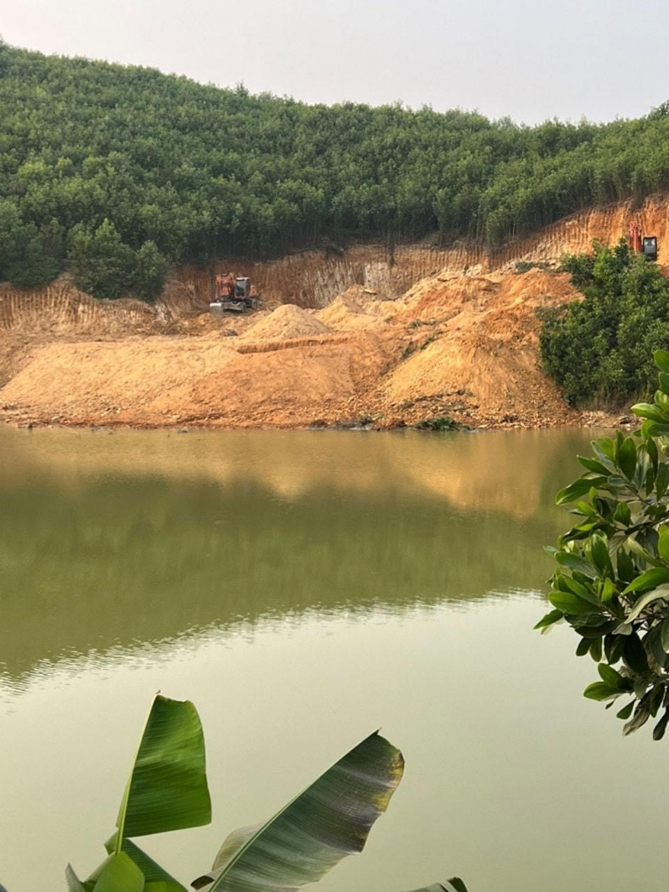 Việc san gạt, hạ đồi, lấp ao hồ Bãi Dài diễn ra công khai giữa ban ngày. Ảnh: Nam Anh.