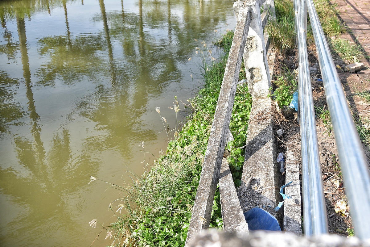 Hình ảnh bờ lan can bị sụt lún, nứt gãy phải gia cố thêm hàng rào sắt phía bên ngoài.