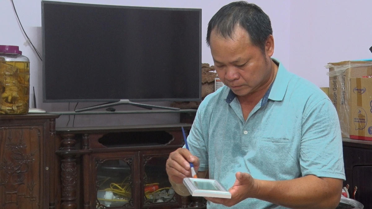 Nghệ nhân Nguyễn Anh Chung (Chủ tịch Hiệp hội Làng nghề dát vàng bạc Kiêu Kỵ) đang quét sơn lên sản phẩm trước khi dát vàng.