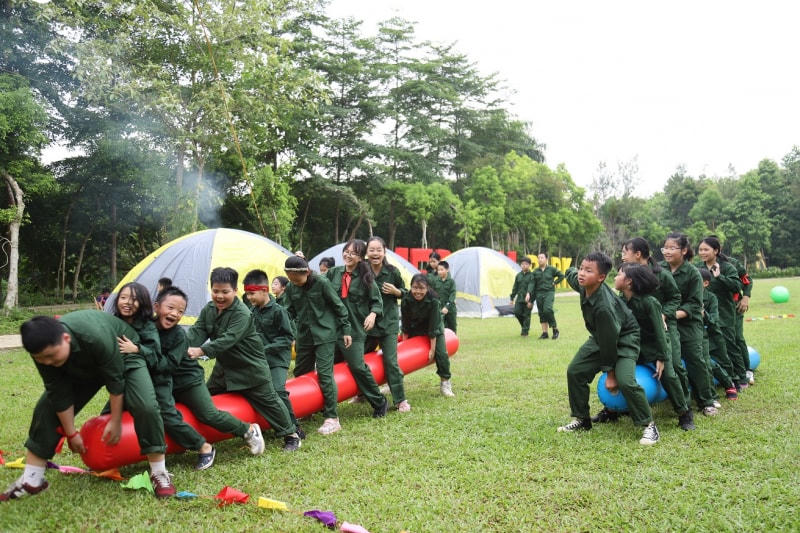 Trẻ em trải nghiệm chơi team building trong khóa trại hè quân đội.  
