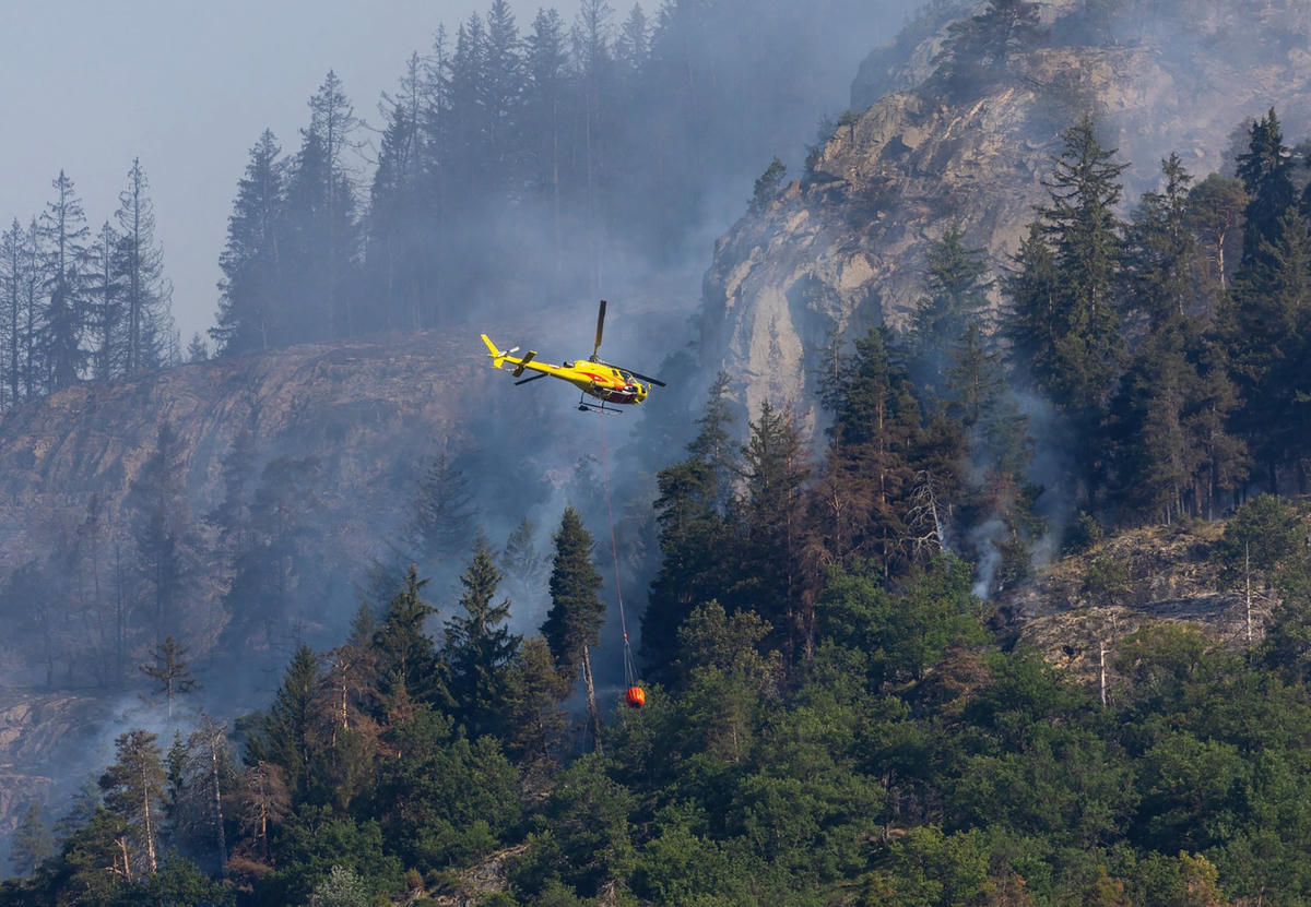 Trực thăng chở nước chữa cháy rừng ở thành phố Bitsch (bang Valais, Thụy Sĩ). Ảnh: REUTERS.