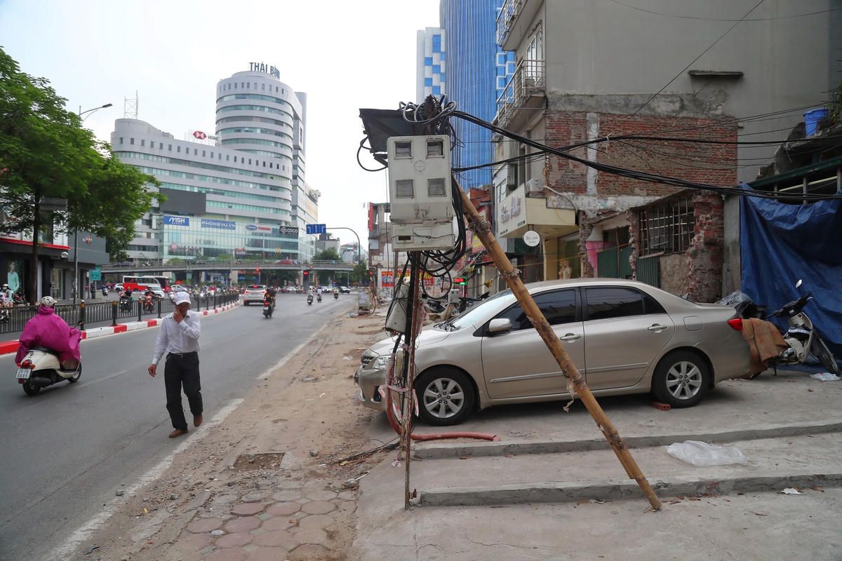 Cột điện bị tháo dỡ các hộ dân sử dụng thang gỗ, cây sắt để chống đỡ.
