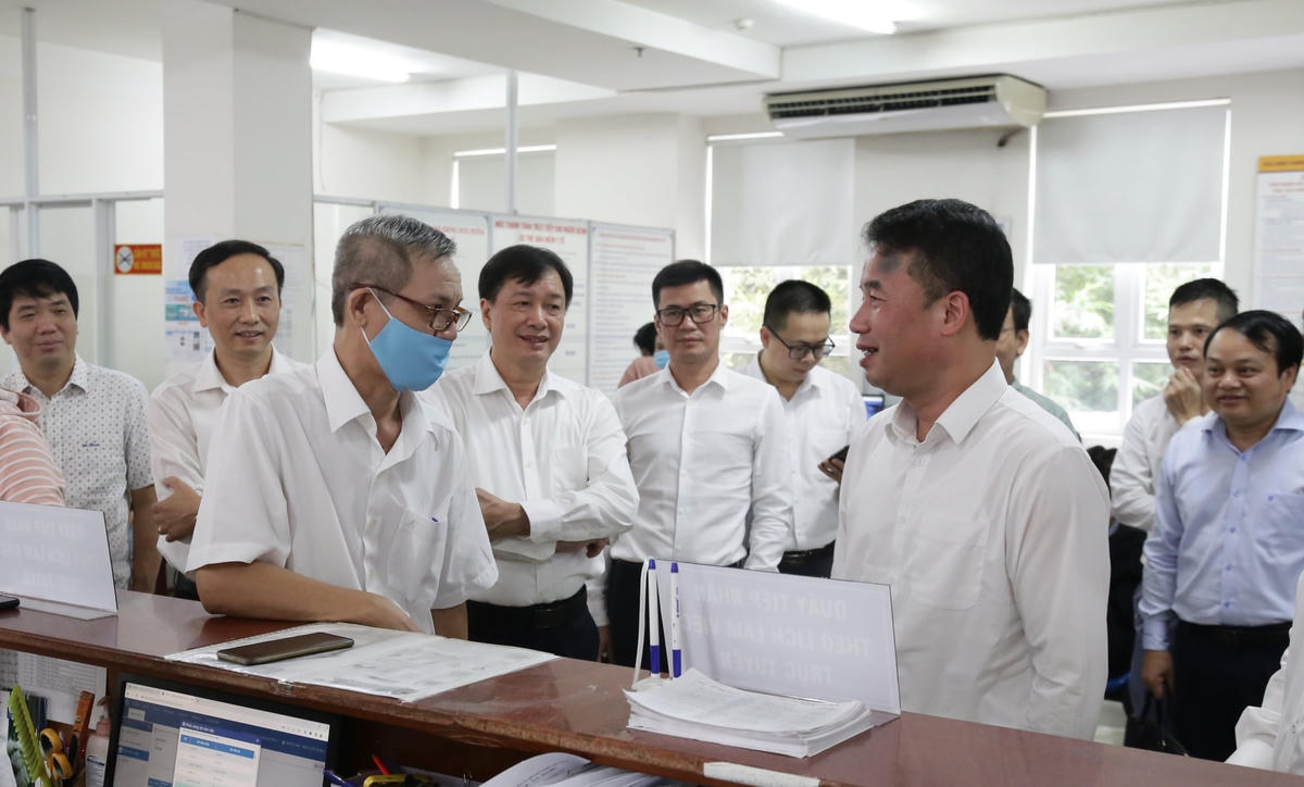 Tổng Giám đốc BHXH Việt Nam Nguyễn Thế Mạnh trao đổi với người dân đến làm việc qua tính năng đặt lịch làm việc trực tuyến tại bộ phận một cửa BHXH T.P Hồ Chí Minh