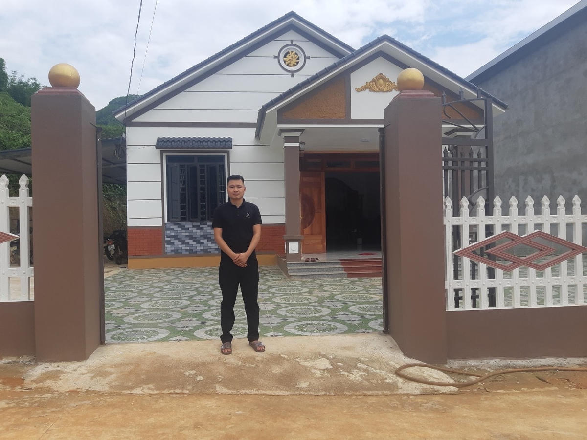 Anh Đinh Văn Nghĩa bên ngôi nhà mới xây nhờ kinh tế quế.  