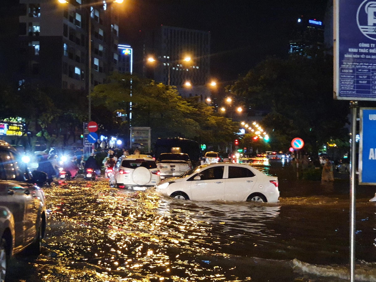 Cơn mưa như trút nước vào khoảng 20h tối nay (13/6) đã làm cho nhiều tuyến đường của Hà Nội tiếp tục ngập sâu. Người và xe bì bõm dưới làn nước.