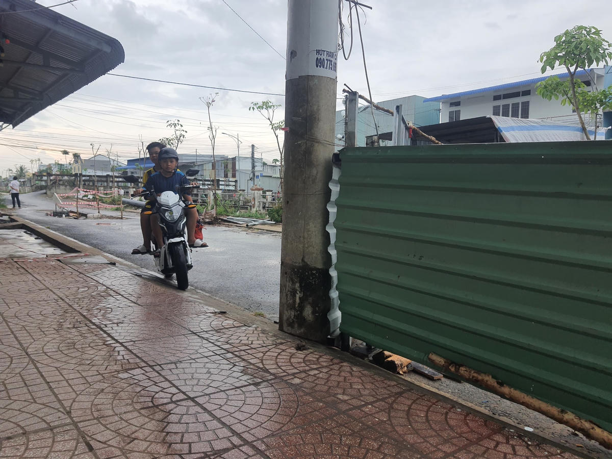 Người dân chật vật lưu thông qua lô cốt án ngữ giữa đường.