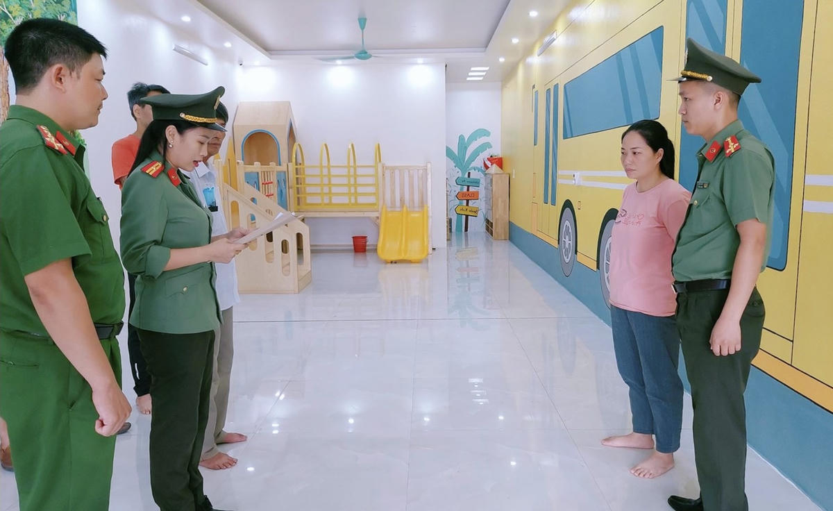 Lê Thị Hồng Vân (áo hồng) nghe Công an đọc lệnh khởi tố, bắt tạm giam.