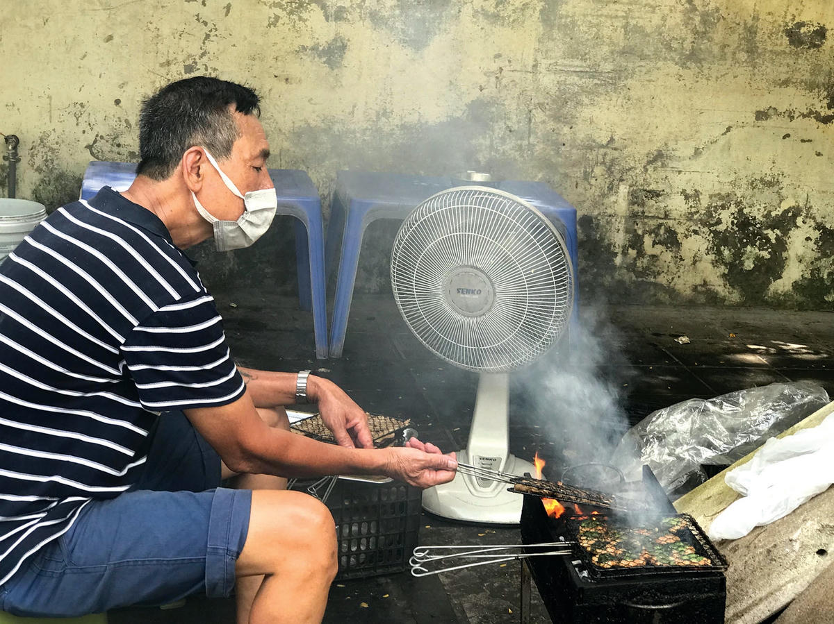 Dù nắng nóng đến mấy, hàng ngày, người đàn ông này vẫn ngồi quạt chả để phụ giúp gia đình bán đồ ăn trưa.  