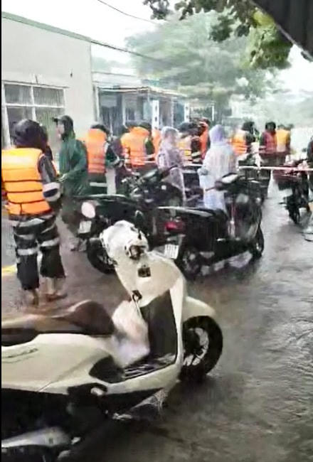 Cảnh sát cơ động hỗ trợ đưa xe máy của người dân đến nơi cao ráo.