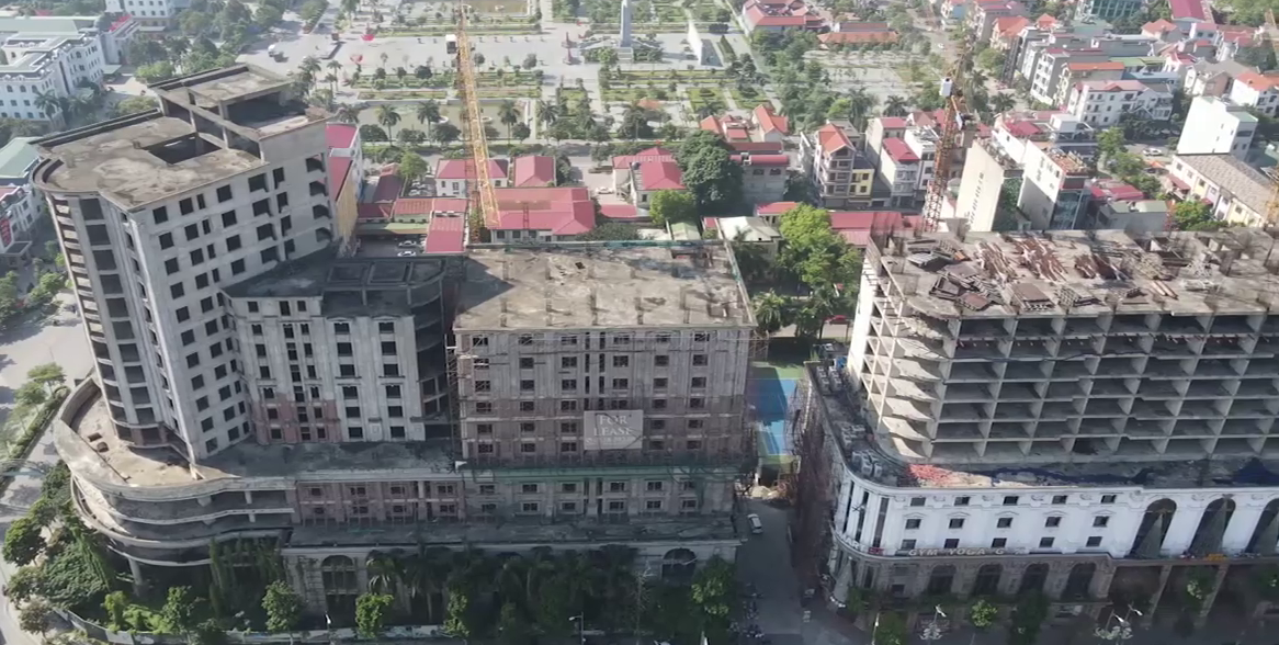 Hệ thống cần cẩu tháp, sắt thép, vật liệu xây dựng nằm chỏng chơ trên nóc tòa nhà.