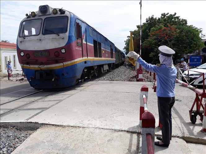 Nhân viên gác chắn đường sắt đảm bảo an toàn cho người dân, phương tiện khi đoàn tàu đi qua.