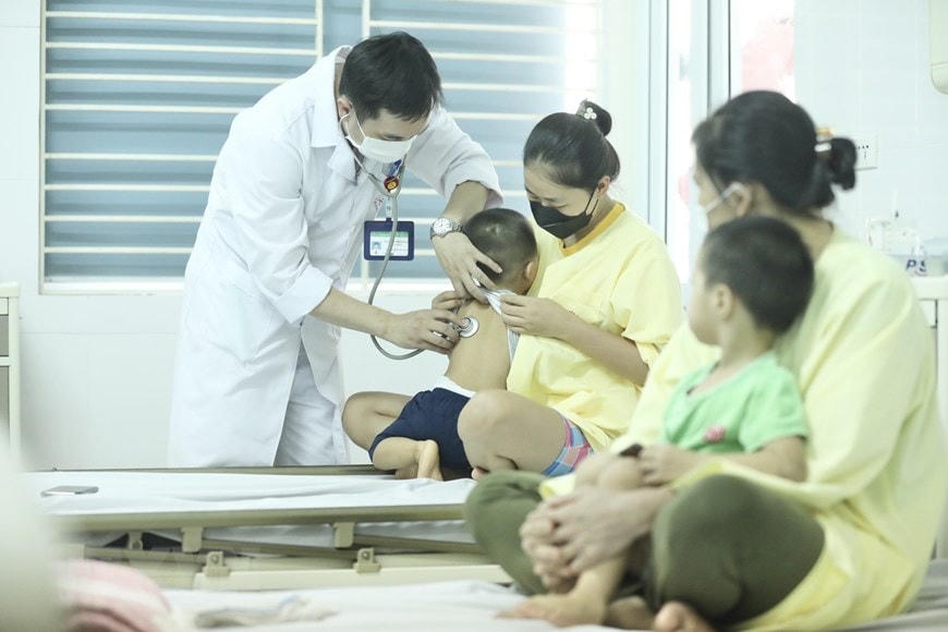 Bác sĩ thăm khám cho bệnh nhi đang điều trị cúm A tại Bệnh viện Bệnh Nhiệt đới trung ương.    Ảnh: TTXVN