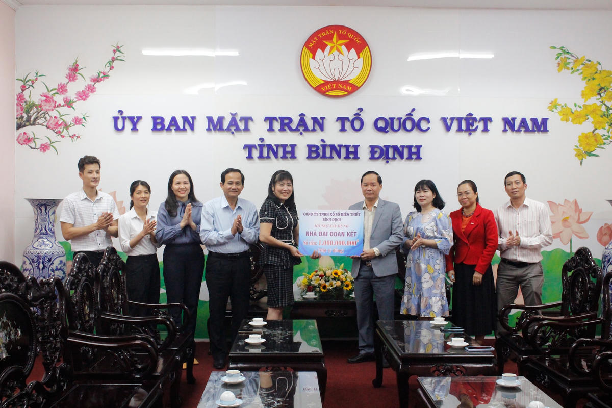 Đại diện Công ty TNHH Xổ số Kiến thiết Bình Định trao bảng hỗ trợ 1 tỷ đồng để xây dựng nhà Đại đoàn kết.
