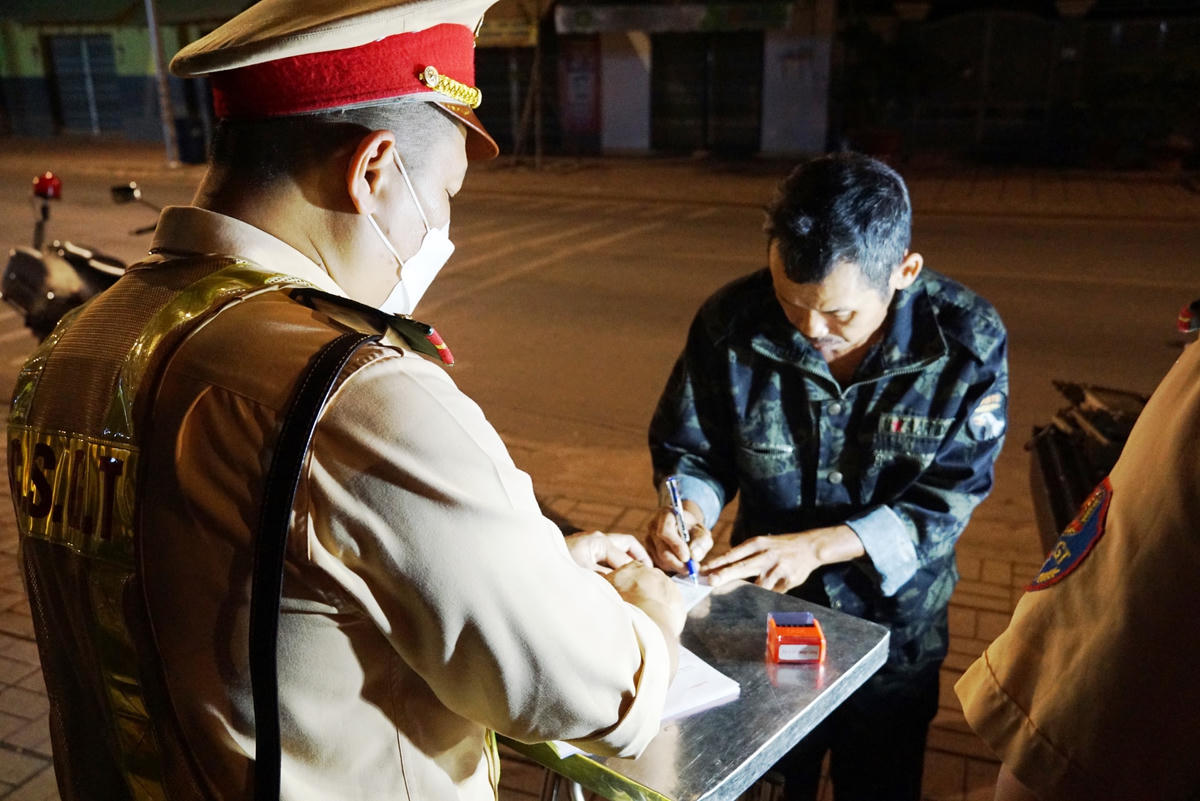 Người vi phạm nồng độ cồn đồng ý ký vào biên bản sau khi có kết quả. Ảnh: Mạnh Thìn.