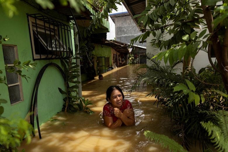 Một phụ nữ lội qua nước ngập đến ngực sau siêu bão Noru, ở San Ildefonso, tỉnh Bulacan, Philippines.