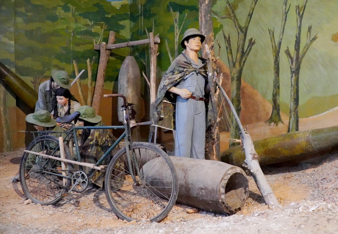 Hình ảnh mô tả phút nghỉ ngơi, trò chuyện của những nữ thanh niên xung phong và bộ đội tại bảo tàng.