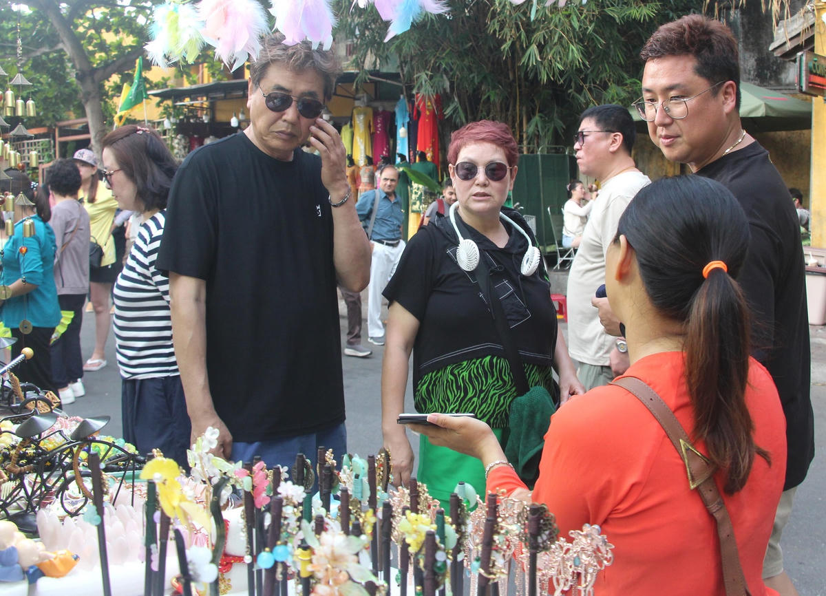 Du khách mua đồ lưu niệm bên đường.