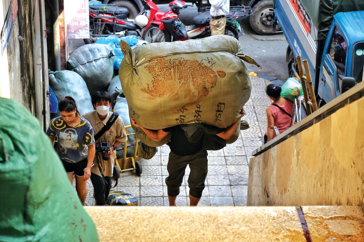 Người đàn ông khuân bao hàng nặng khoảng 100 kg di chuyển từ tầng 1 lên tầng 3 của khu chợ.  