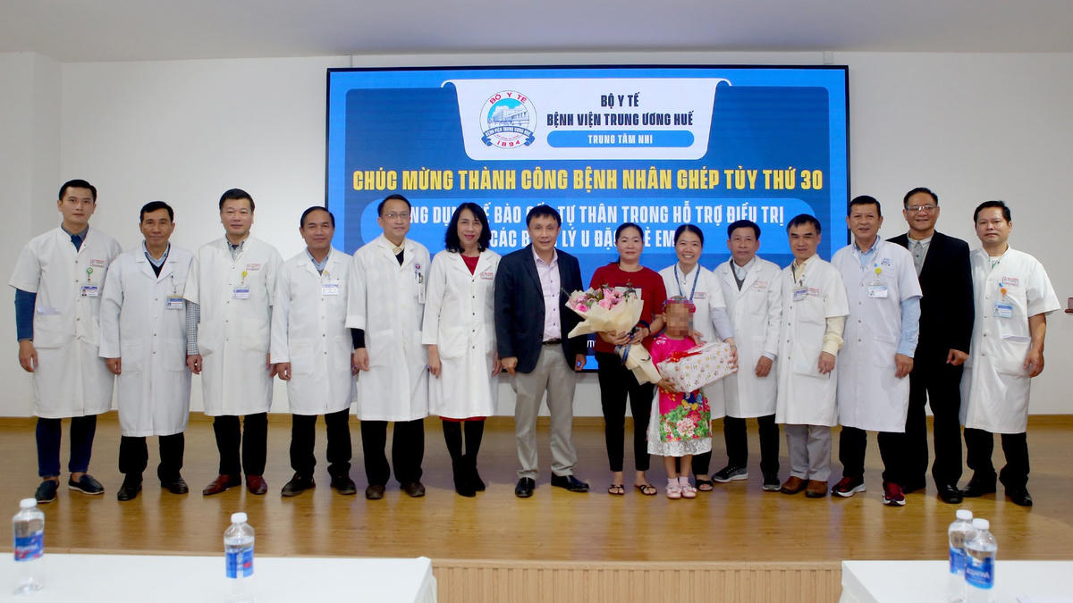Lãnh đạo Bệnh viện Trung ương Huế tặng hoa chúc mừng cháu bé được ra viện.
