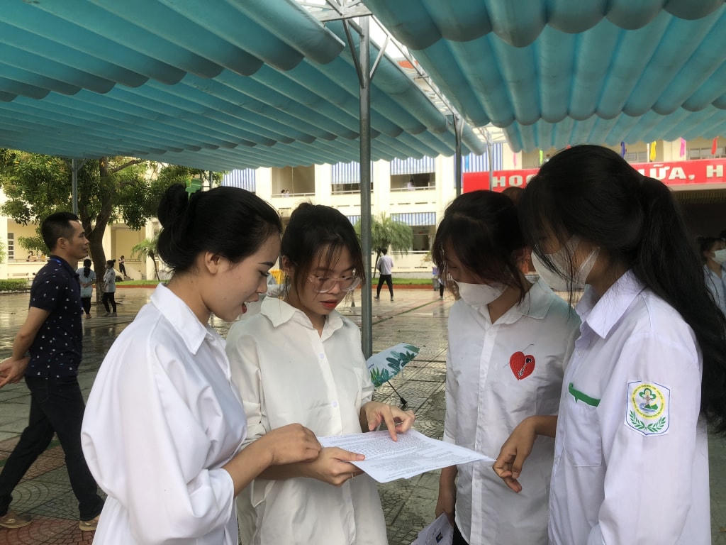 Thí sinh trao đổi bài sau khi kết thúc môn thi đầu tiên. Ảnh: QMG. 