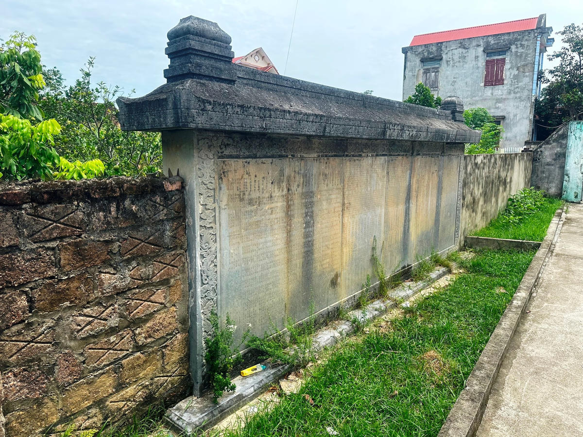 Tấm bia cổ lớn được người dân dùng làm một phần bờ tường rào.