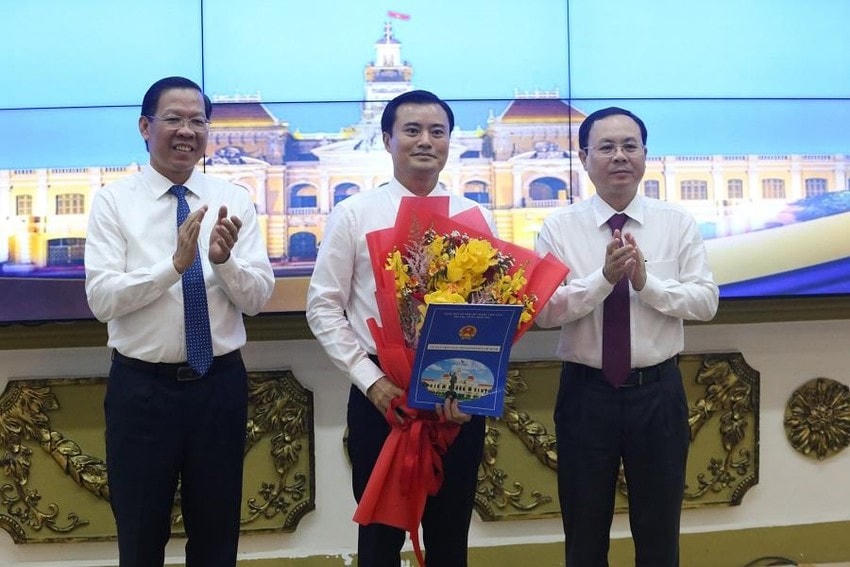 Phó Bí thư Thành ủy TP HCM Nguyễn Văn Hiếu và Chủ tịch UBND TP HCM Phan Văn Mãi trao quyết định phê chuẩn, hoa chúc mừng đến tân Phó Chủ tịch UBND TP Bùi Xuân Cường. Ảnh: PLO.