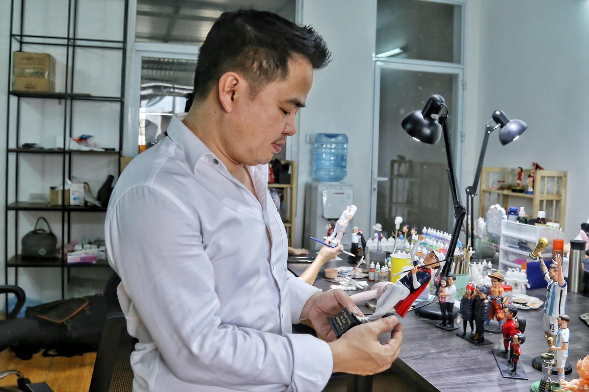 Anh Phan Văn Thắng, chủ cơ sở chế tác tượng mini Funface tại Hà Nội đang xem lại bức tượng golf Lê Khánh Hưng dành huy chương Vàng.