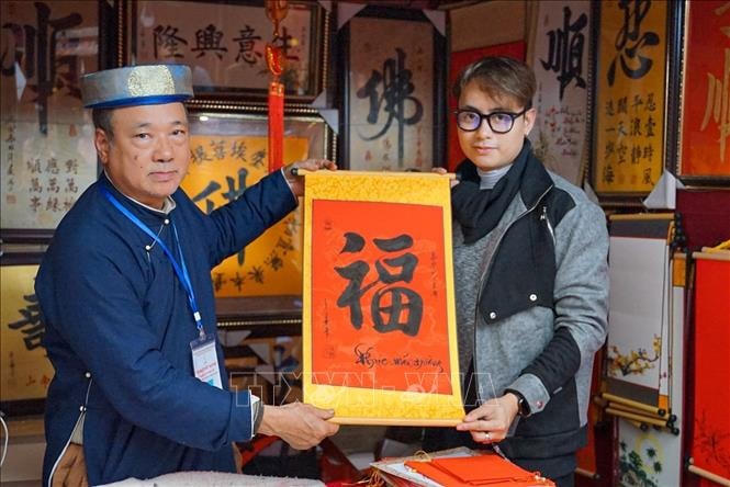 Một bạn trẻ thích thú nhận chữ mới xin ngày mùng 2 Tết Quý Mão ở Hội chữ Xuân Quý Mão 2023.