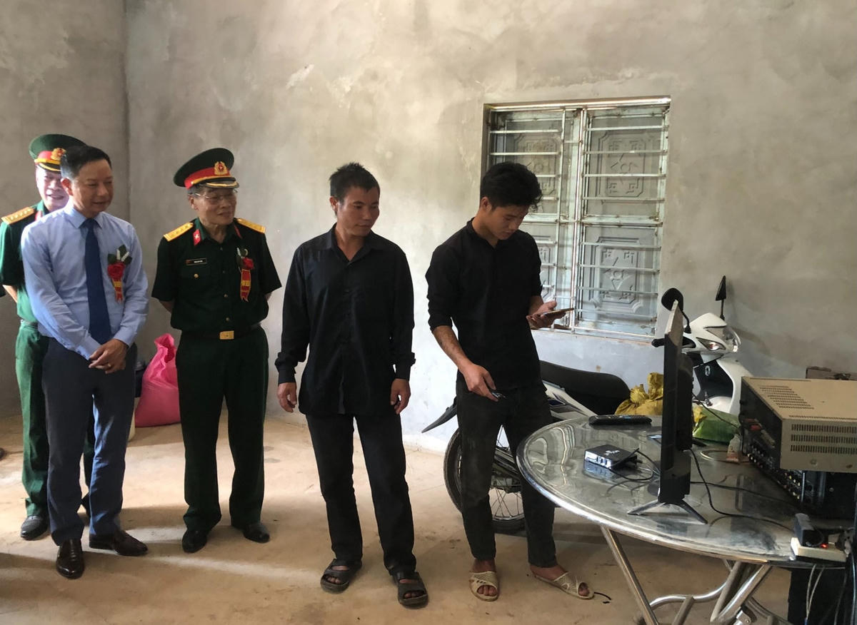 Ông Dòong A Si (thứ hai từ bên phải) phấn khởi giới thiệu về ngôi nhà mới.